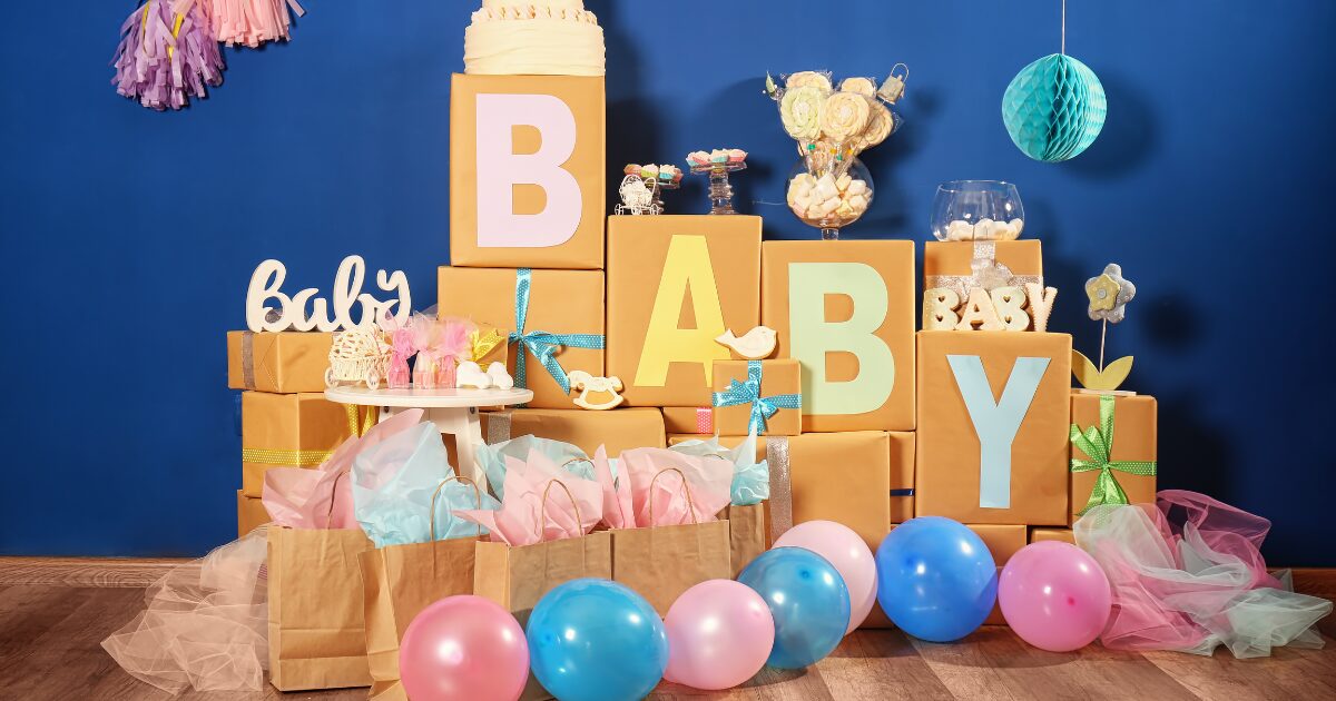 tres-mujeres-una-de-ellas-embarazada-con-globos-azules-y-rosas-y-confeti-azul-celebrando-un-baby-shower